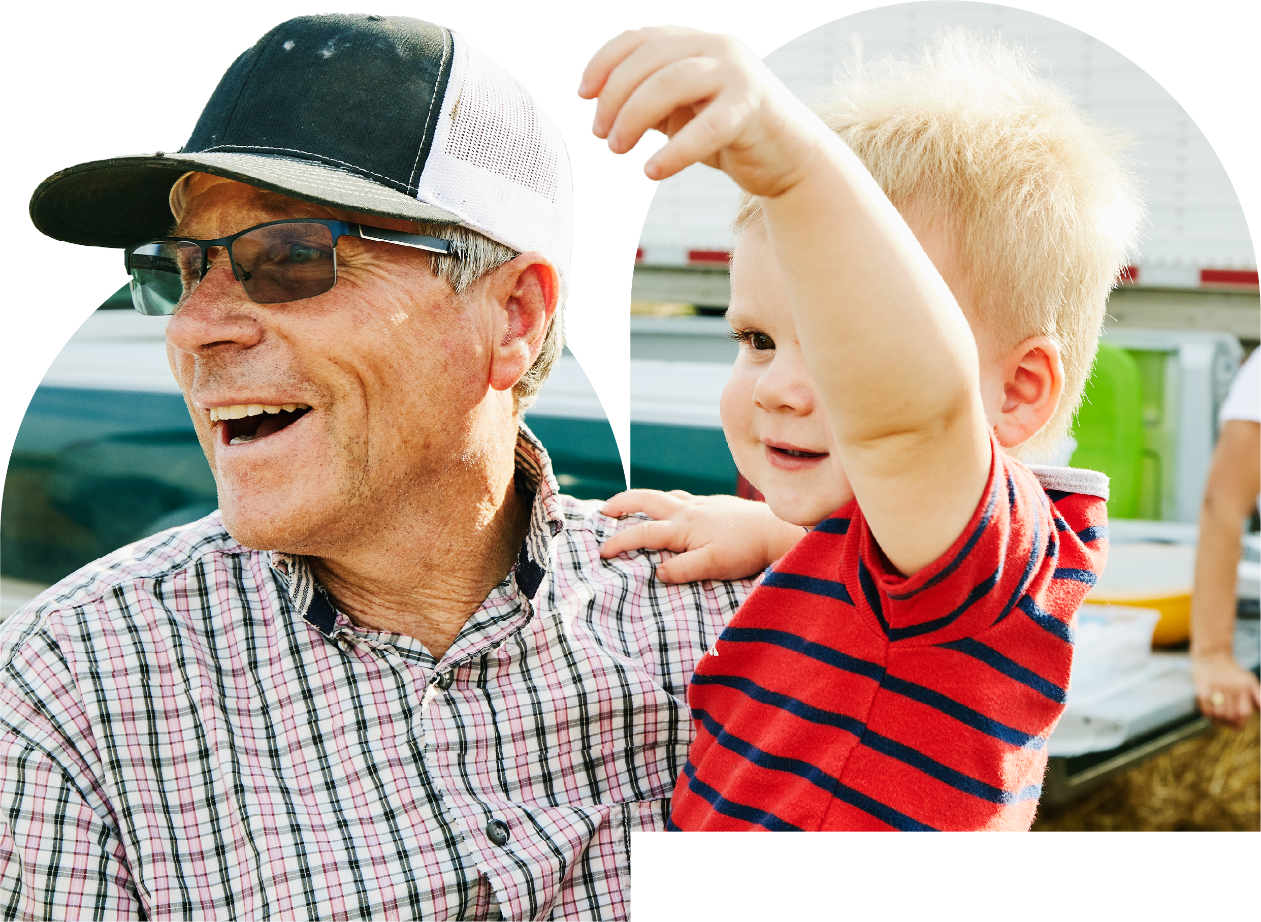 An older man wearing a hat holds a child.